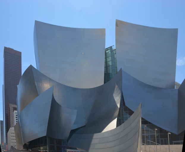 Moderner Glas-Konzertsaal mit Treppen und Geländern, die zum Eingang führen, umgeben von Menschen, anderen Gebäuden und einem klaren blauen Himmel in Los Angeles.