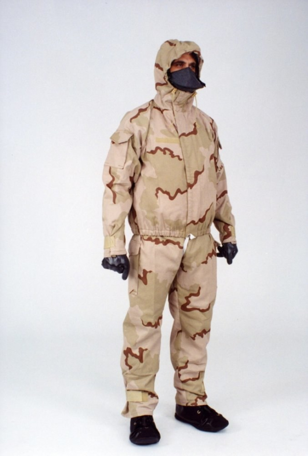 Ein Mann in einem Ganzkörper-Camouflage-Schutzanzug und Maske steht vor einem weißen Hintergrund.