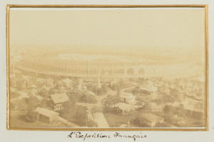 Altes Schwarz-Weiß-Foto eines Stadions, umgeben von Stadtgebäuden, Bäumen und Strommasten mit Text unten.