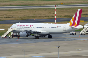 Ein Airbus A320-200 der Germanwings auf dem Frankfurter Flughafen, mit Fahrzeugen, Verkehrskegeln, Pfosten und Gras im Hintergrund.
