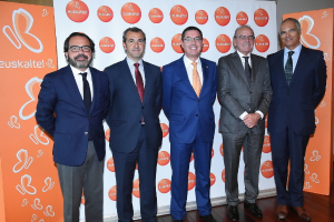 Eine Gruppe von Männern, die für ein Foto posieren und Banner mit dem Namen einer Organisation im Hintergrund halten.