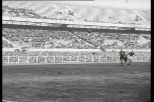 Ein Schwarz-Weiß-Foto eines Fußballspiels in einem Stadion, mit Spielern auf dem Feld und Zuschauern in den Rängen, beschriftet mit "1961-1962 Niederländische Fußball-Meisterschaftsfinale".