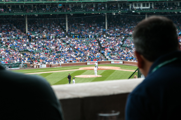 Baseball-Spiel in einem Stadion mit Menschen in der foreground und einer Menge in den Rängen.