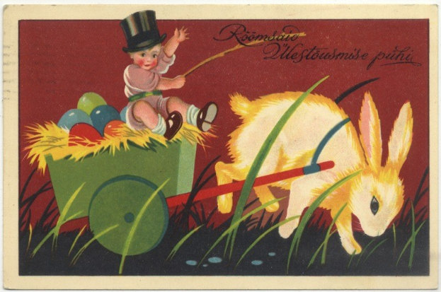 Ein altes Postkartenset mit einem Baby in einem Zylinder, das einen Karren voller bunter Ostereier schiebt und von einem Hasen begleitet wird, mit handgeschriebener Textzeile zum Glückwünschen eines frohen Osterns.