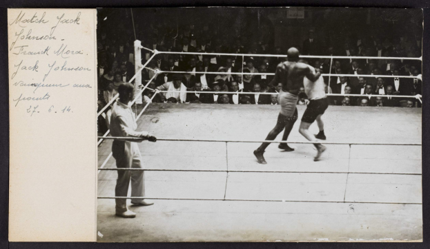 Schwarz-weiß-Foto von zwei Boxern im Ring mit einem Schiedsrichter und Zuschauern, betitelt "Jack Johnson vs Frank Morgan".