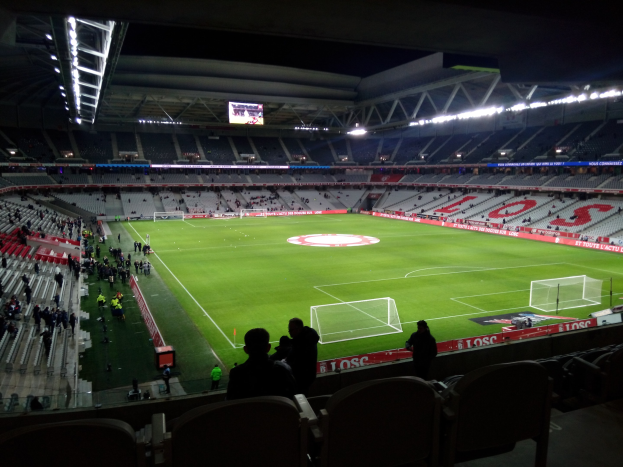 Großes Stadion voller Zuschauer bei einem Fußballspiel im Estadio Santiago Bernabeu in Madrid, Spanien, unter Flutlicht mit einem Bildschirm oben.