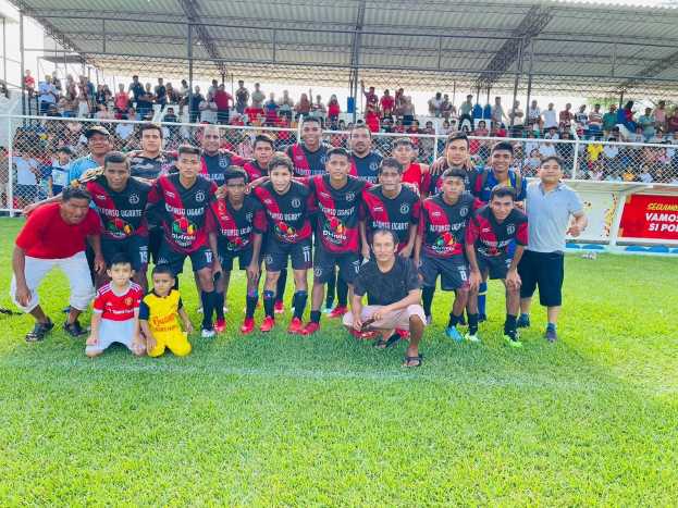 Gruppe von Männern auf einem Fußballfeld mit einem Siegesschild, das "Fotos Ugarte U-17 vs U-18" lautet.