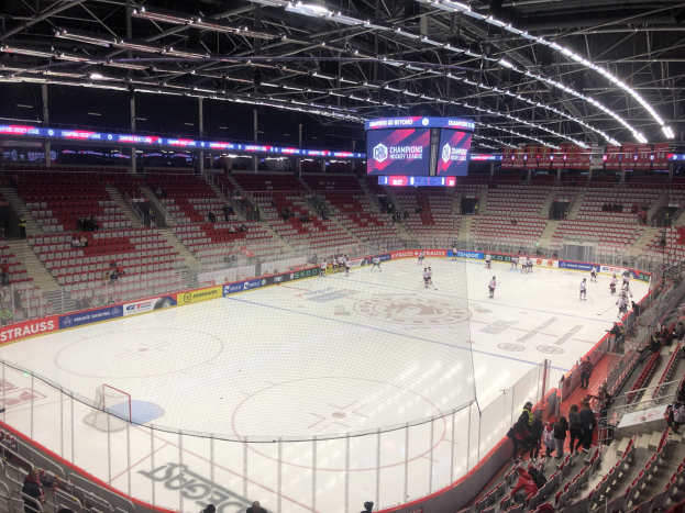 Eishockeyspiel in einer großen Arena zwischen den St. Louis Blues und den Detroit Red Wings, mit Zuschauern, die in der Nähe der Eisfläche sitzen und stehen.
