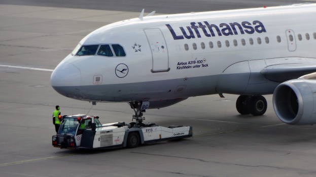 Lufthansa Airbus A319-100 auf dem Frankfurter Airport mit einem Bodenfahrzeug und einer Person in der Nähe, bereit zum Start.